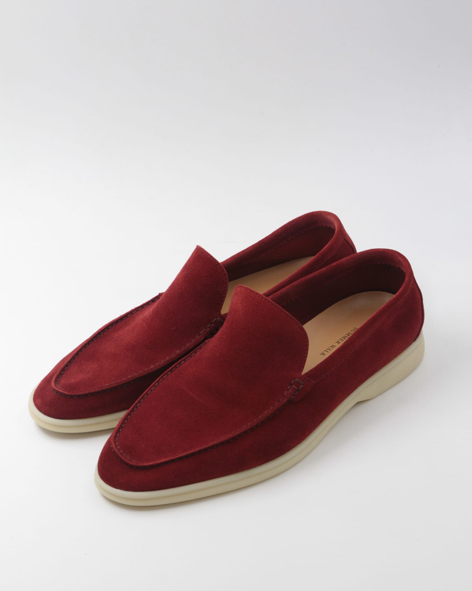 The same burgundy suede loafers after restoration, the suede colour renewed and a clean replacement sole fitted.